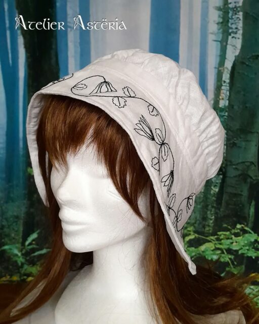 L’adorable coiffe de @casta_hex m’a donné envie de faire une version de cette coiffe Renaissance. Elle est en lin blanc et j’ai brodé à la machine un motif de fleurs et feuilles d’ancolie que j’ai dessiné en m’inspirant de motifs d’époque. Le motif est disponible en noir et en rouge pour rappeler les broderies "black work" et "red work" appréciées à la Renaissance. J’aime beaucoup le résultat. Et vous ?.En : @casta_hex ’s adorable coif inspired me to make my own version of this Renaissance coif. It’s made of white linen, and I machine-embroidered a pattern of columbine flowers and leaves that I designed myself, drawing inspired from period motifs. The pattern is available in black and red to evoke the “black work” and “red work” embroidery styles popular during the Renaissance. I really like how it turned out. What about you?